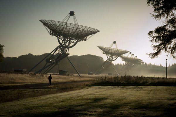 Radiotelescopen met een persoon op de voorgrond