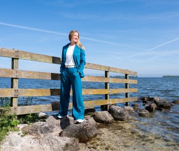 Maaike Romijn staat op een rij stenen die uitsteekt in het water