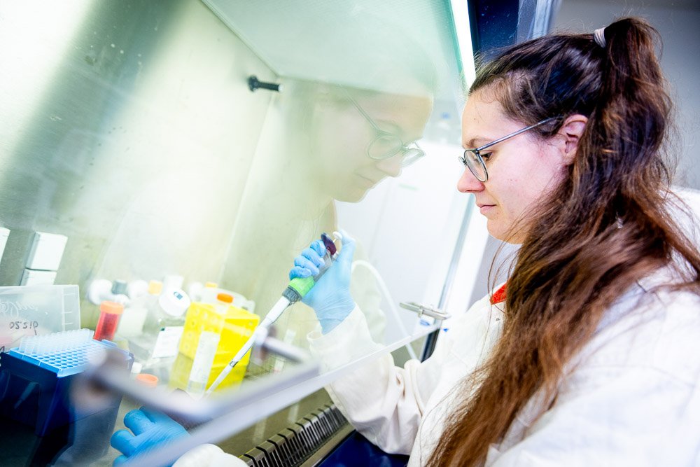 Vrouw in labjas werkt met pipet in laboratorium