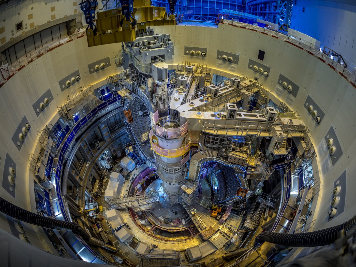 Grote open ronde ruimte met allerlei trapjes en steigers die de tokamak reactor van ITER wordt