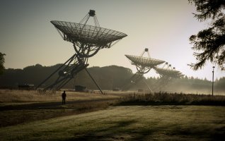 Radiotelescopen met een persoon op de voorgrond