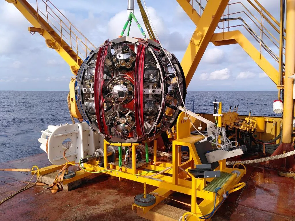 Een detector van KM3NeT staat op een schip, klaar om in het water getakeld te worden